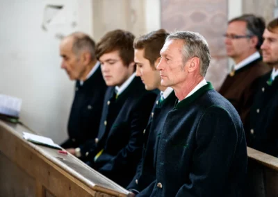 Männer in Tracht bei einer kirchlichen Trauung. Hochzeitsreportage in Valley Oberbayern, südlich von München.