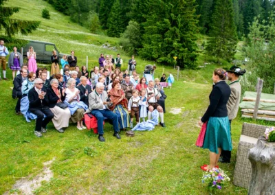 Brautpaar steht vor applaudierenden Gaesten bei Hochzeit im Sillberghaus Bayrischzell, umgeben von Natur.