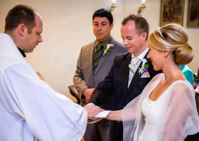 Kirchliche Trauung in Muenchen, Brautpaar und Priester bei Hochzeitszeremonie. Hochzeitsfoto von Fotograf in Pasing.