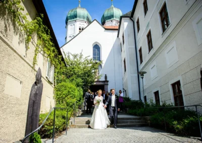 Brautpaar nach kirchlicher Trauung im Kloster Seeon, Chiemgau, umgeben von historischer Architektur und Natur.