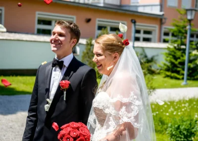 Bräutigam im Anzug und Braut im Spitzenkleid lächelnd im Freien. Hochzeitsreportage in Garmisch.