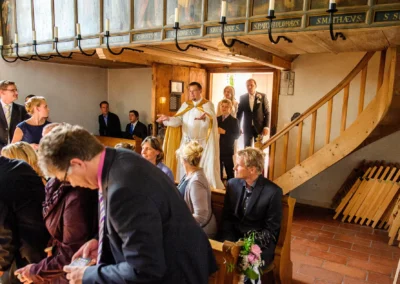 Kirchliche Trauung in Grosshadern, Hochzeitsreportage zeigt Priester beim Einzug mit Brautpaar und Gaesten in der Kirche.