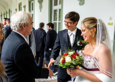 Braut und Braeutigam empfangen Gaeste bei ihrer Hochzeit nahe Bad Toelz, aufgenommen von einem Hochzeitsfotografen.