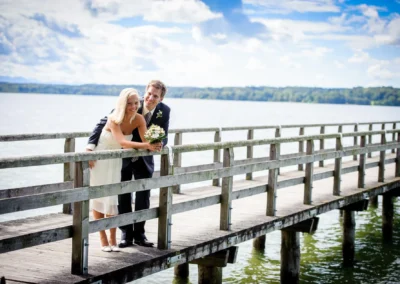 Hochzeitsfoto von einem paar auf einem steg am starnberger see, aufgenommen bei einer Hochzeit südlich von München.