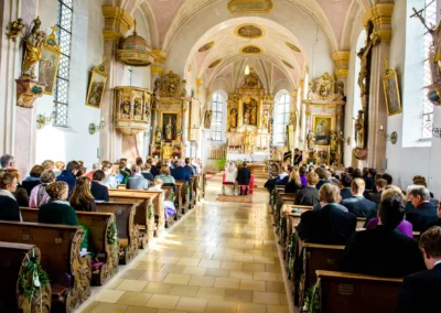 Kirchliche Trauung in Valley, Brautpaar vor Altar, Gaeste sitzen in Kirchenbaenken, Hochzeitsreportage.
