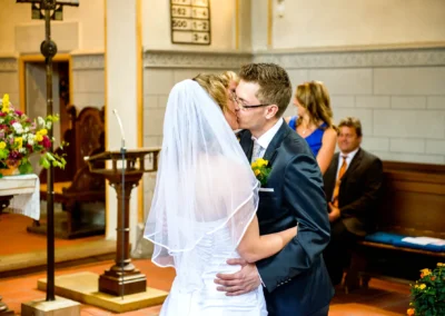Brautpaar tauscht Kuss bei kirchlicher Trauung in der evangelischen Friedenskirche Starnberg. Hochzeitsreportage.