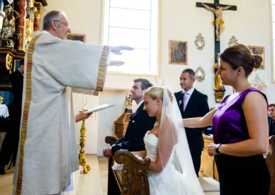 Priester segnet Brautpaar bei kirchlicher Trauung in Taufkirchen nahe Muenchen, Hochzeitsreportage in einer Kirche.