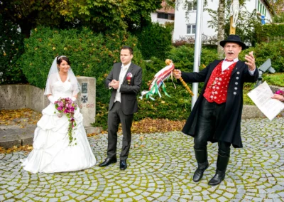 Brautpaar und Mann in traditioneller Tracht bei kirchlicher Hochzeit in Gilching, aufgenommen von Hochzeitsfotograf.