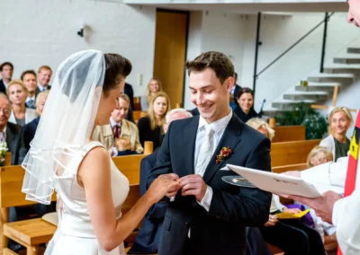 Brautpaar tauscht Ringe während kirchlicher Trauung in Feldafing am Starnberger See, Hochzeitsreportage.