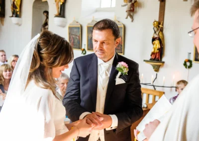 Braut und Braeutigam tauschen Ringe bei kirchlicher Trauung in Sankt Peter. Hochzeitsfotografie in Muenchen.