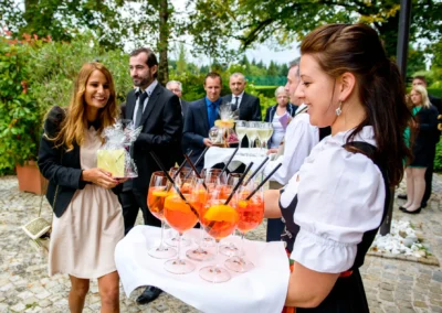 Gaste bei Hochzeit nahe Tegernsee empfangen Drinks. Hochzeitsfotografie von Hochzeitsreportage.