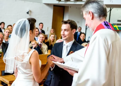 Brautpaar bei kirchlicher Trauung in Feldafing, begleitet von Familie und Freunden, Hochzeitsfotografie in Kirche.