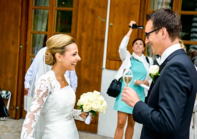 Fröhliches Brautpaar bei Hochzeitsfeier mit Champagner in Waakirchen, aufgenommen von Hochzeitsfotograf.