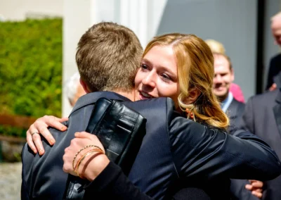 Eine Frau umarmt einen Mann bei einer Hochzeitsfeier an der evangelischen Friedenskirche, Starnberger See.