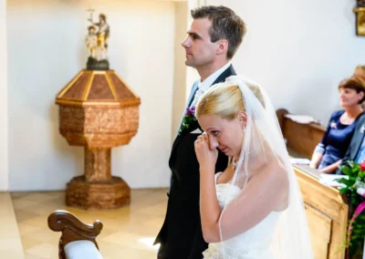 Brautpaar bei kirchlicher Trauung in Taufkirchen bei München, emotionaler Moment der Hochzeitsfotografie.
