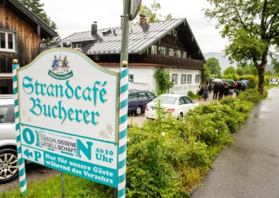 Hochzeitsreportage am Strandcafe Bucherer, Gäste im Regen. Szenen einer Hochzeit. Hochzeitsfotografie in Bayern.