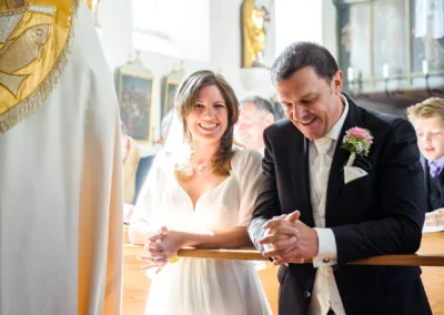 Brautpaar laechelt bei kirchlicher Trauung in Grosshadern. Hochzeitsfotograf in Muenchen erfasst den Moment perfekt.