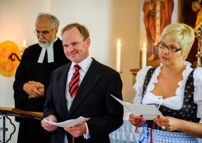 Mann und Frau lesen bei kirchlicher Trauung in gut thurnsberg, Hochzeitsreportage.