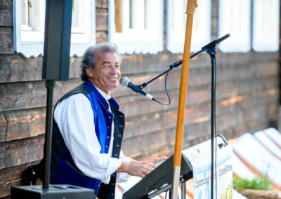 Musiker in Tracht spielt Keyboard bei Hochzeit im Sillberghaus. Hochzeitsfotograf aus Muenchen dokumentiert den Moment.