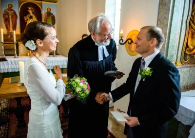 Brautpaar bei der kirchlichen Trauung mit Pastor auf Gut Thurnsberg, Hochzeitsfotografie in Oberbayern.