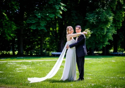 Brautpaar umarmt sich in einem Park, Hochzeitsportrait im Luitpoldpark Muenchen, Hochzeitsfoto im Gruenen.