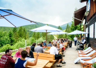 Hochzeitsgesellschaft auf Terrasse im Sillberghaus, eine Hochzeitsreportage in Bayrischzell mit idyllischem Bergblick.