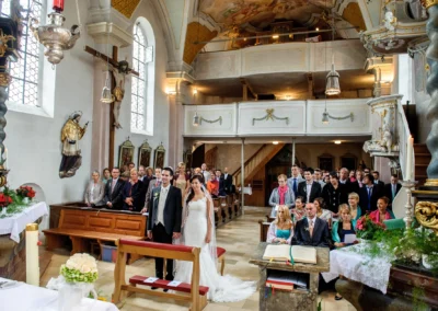 Kirchliche Trauung in der Pfarrkirche Sankt Michael mit Brautpaar und Gästen, Teil einer Hochzeitsreportage.
