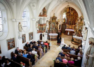 Kirchliche Trauung in einer Kapelle in Bernried, Hochzeitsfoto mit Brautpaar und Gaesten.