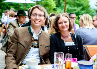 Elegantes Paar in Tracht lacht bei einer Hochzeit in Bayrischzell im Freien, Hochzeitsfoto von Feier.