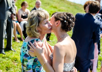 Junge Frau umarmt aeltere Frau bei einer Hochzeitsfeier im Freien, Hochzeitsreportage bei Aschau im Chiemgau.