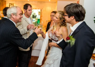 Hochzeitsgäste stoßen in Walchensee mit Sektgläsern an. Hochzeitsfoto zeigt festlichen Moment bei einer Hochzeit.