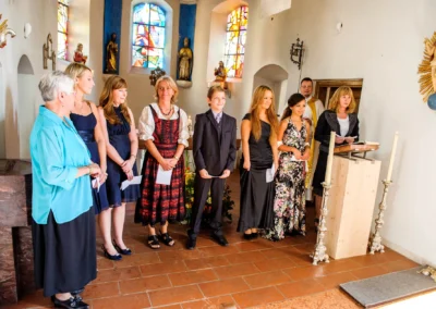 Gruppenszene bei kirchlicher Trauung in Stankt Peter, Hochzeit in Muenchen, festliche Kleidung und Dekoration sichtbar.