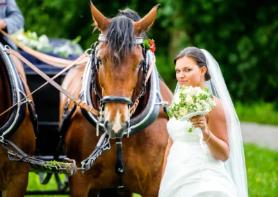 Braut mit Blumenstrauss neben Pferd bei Hochzeitsreportage am Staffelsee, eingefangen von Hochzeitsfotograf.