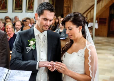 Braut und Braeutigam tauschen Ringe waehrend der kirchlichen Hochzeit in der Pfarrkirche Sankt Michael, Hochzeitsfotografie.