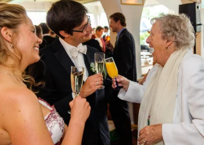 Hochzeitsfoto: Personen stoßen mit Sekt und Saft an bei einer Hochzeit im Strandcafe Bucherer.
