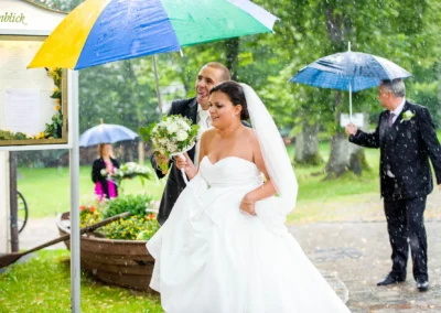 Brautpaar unter Regenschirm bei Hochzeit am Staffelsee fotografiert, romantische Hochzeitsreportage im Regen.