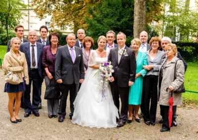 Gruppenfoto bei der standesamtlichen Trauung in Muenchen mit Brautpaar und Gaesten im Freien. Hochzeitsfotograf.