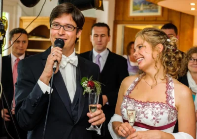 Bräutigam hält Rede auf Hochzeit mit Braut, Walchensee. Feierliche Hochzeitsreportage in festlichem Ambiente.