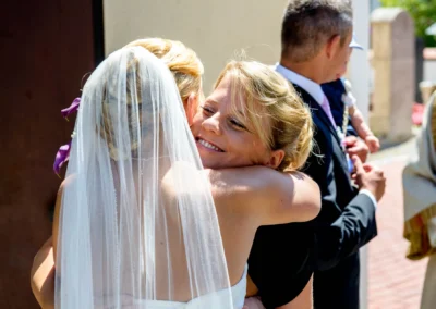 Braut umarmt Gast bei kirchlicher Trauung in Taufkirchen nahe Muenchen, festgehalten in einem Hochzeitsfoto.