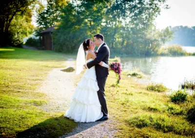 Brautpaar bei Hochzeitsportraits im Paulaner Seegarten, umgeben von Natur und Seenlandschaft. Hochzeitsfoto-Idylle.