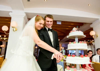 Brautpaar schneidet Hochzeitstorte an, Hochzeitsfoto im Hotel am Badersee, nahe Zugspitze, Kreis Garmisch-Partenkirchen.