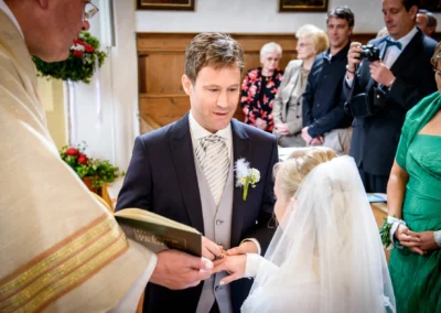 Brautpaar tauscht Ringe bei kirchlicher Trauung in Schaftlach, festgehalten von Hochzeitsfotograf.