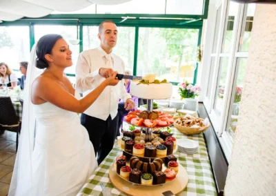 Brautpaar schneidet Hochzeitstorte bei der Feier im Restaurant Alpenblick am Staffelsee, festgehalten in einer Hochzeitsreportage.