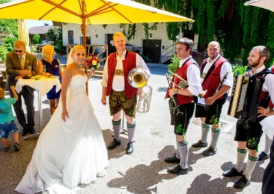 Braut mit traditioneller Blaskapelle bei Hochzeit im Landgasthof Stahuber, Hochzeitsfotografie südlich München.