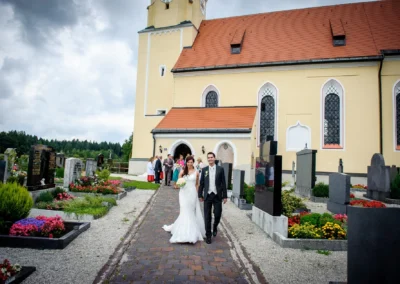 Brautpaar verlässt Kirche nach Trauung in Pfarrkirche Sankt Michael, Hochzeitsszene in Arget, Landkreis Muenchen.
