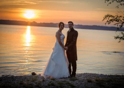 Brautpaar am Starnberger See bei Sonnenuntergang, romantische Hochzeitsfotografie mit Blick auf das Wasser.