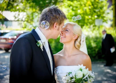 Brautpaar mit Blumenstrauß und Seifenblasen, Hochzeitsfotografie in Bernried am Starnberger See, aufgenommene Momente.