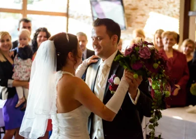 Brautpaar tanzt auf ihrer Hochzeit mit Gaesten im Hintergrund in Karlsfeld, festgehalten von einem Hochzeitsfotografen.