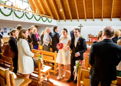 Brautpaar verlaesst Kirche nach Trauung in Feldafing am Starnberger See, gaeste klatschen. Hochzeitsfoto.