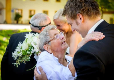 Brautpaar mit Familie, emotionaler Moment bei Hochzeitsreportage in Bernried am Starnberger See. Hochzeitsfoto.